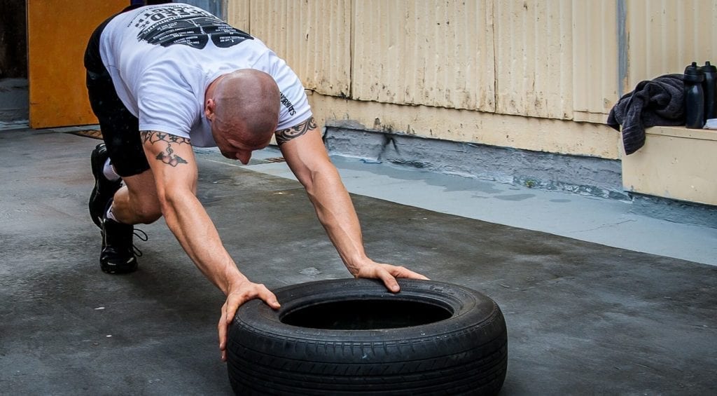 Man pushing a tyre on floor exercise