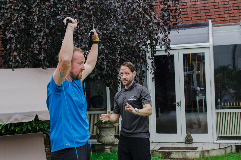 Shoulder press with resistance bands - personal training in the garden