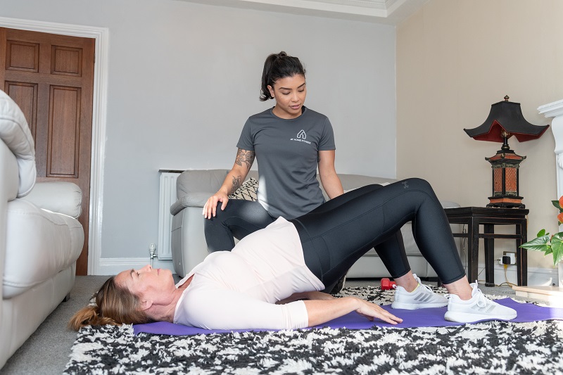 Heleyna helping client with glute bridge for home fitness